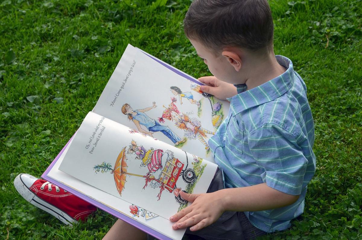 Boy reading picture book @ LitPick Book Reviews.